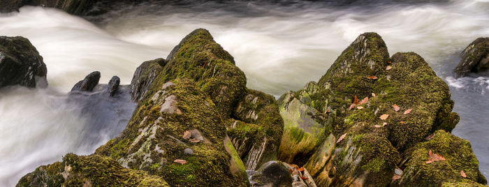 Panoramic view of rocks and sea against sky