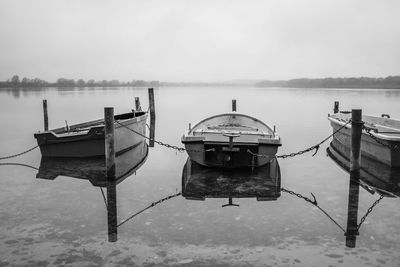 Boats moored in lake against sky