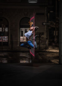 Full length of woman jumping against wall