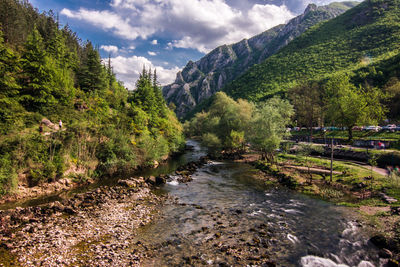 Scenic view of river amidst mountains against sky