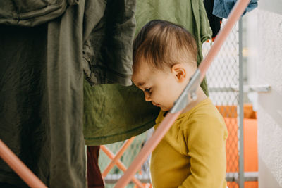 Cute boy with clothes at home