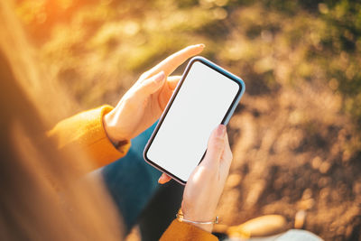 Midsection of person photographing with mobile phone