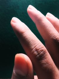 Close-up of human hand against wall