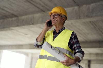 Low angle view of engineer talking on phone at site