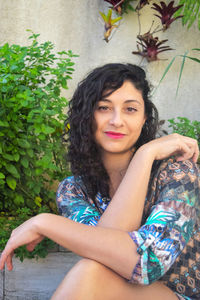 Portrait of a smiling young woman sitting outdoors