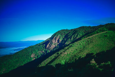 Scenic view of mountains against blue sky