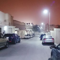 Cars parked on illuminated street at night