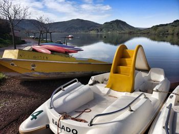 Boats moored in lake against sky