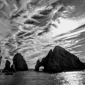 Panoramic view of rocks by sea against sky