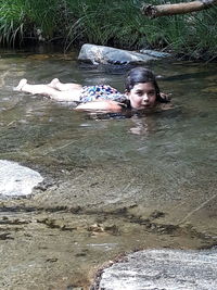 Portrait of woman lying down on water