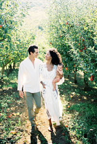 Rear view of couple walking on field