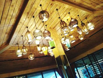 Low angle view of illuminated chandelier hanging on ceiling