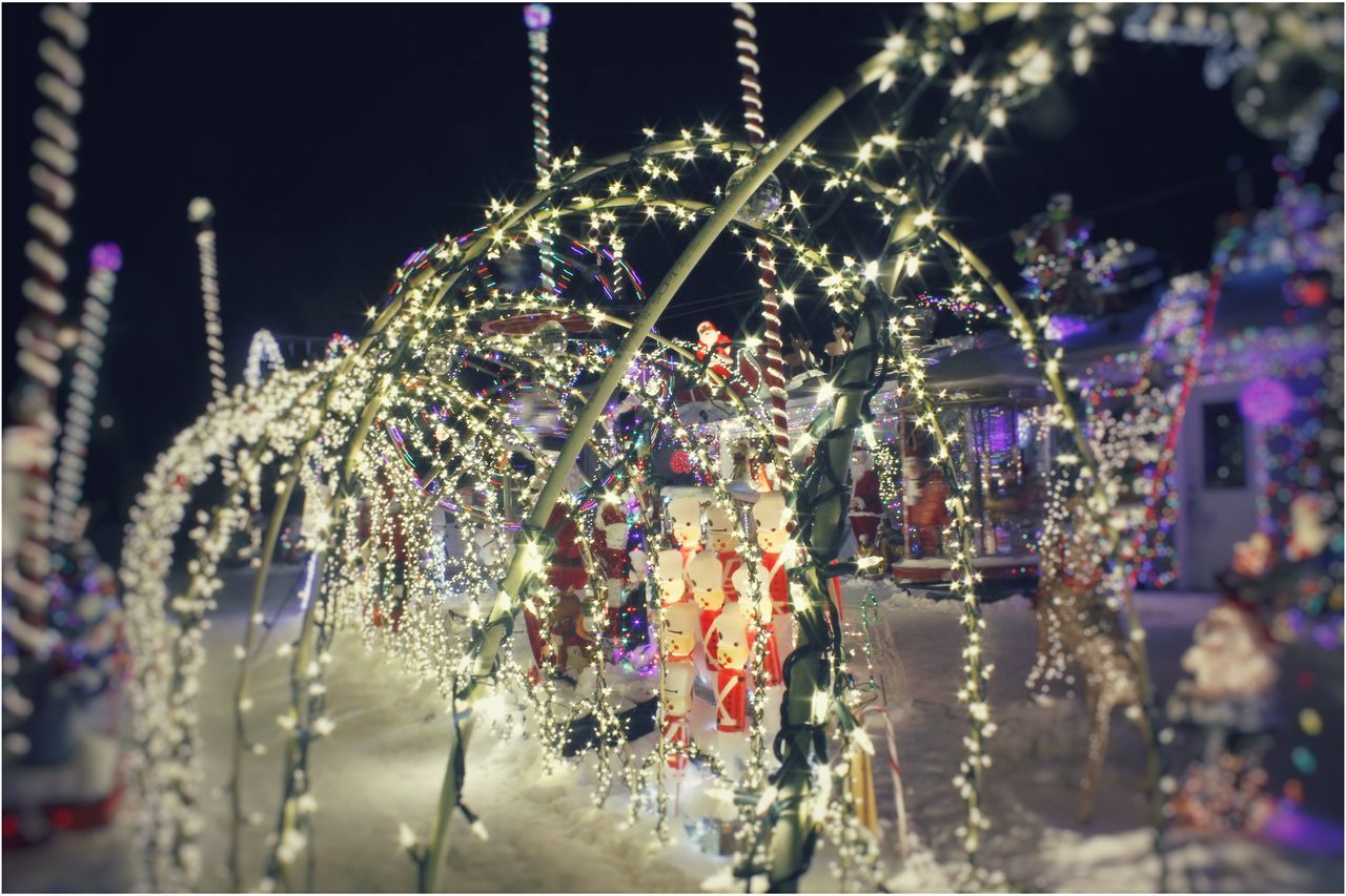 focus on foreground, water, decoration, illuminated, hanging, multi colored, reflection, close-up, selective focus, building exterior, night, celebration, built structure, architecture, city, outdoors, incidental people, christmas decoration, no people, fountain