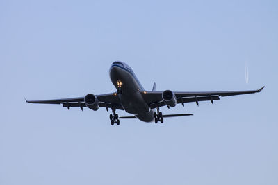 Low angle view of airplane against clear blue sky