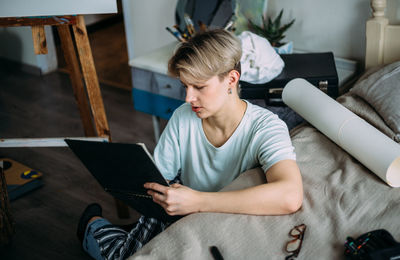 Young man using mobile phone at home