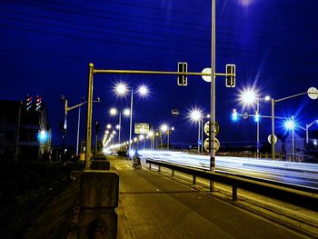 Illuminated street light against sky at night