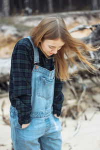 Beautiful young woman walking along the seashore in autumn