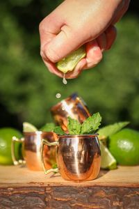 Close-up of hand holding fruit on table