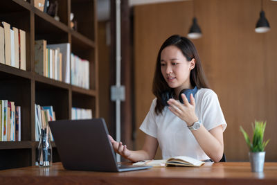 Young woman using laptop at table