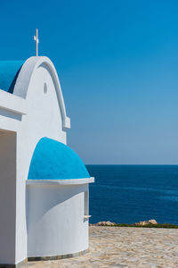 Traditional greek white chapel with a blue roof on the seaside. agioi anargyroi chapel, cyprus