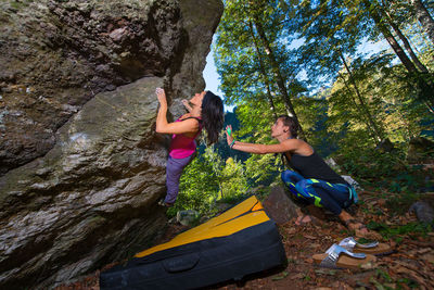 Woman standing on rock against trees