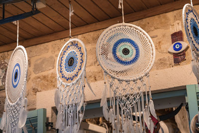 Dreamcatchers with evil eyes and feathers hanging for sale at market