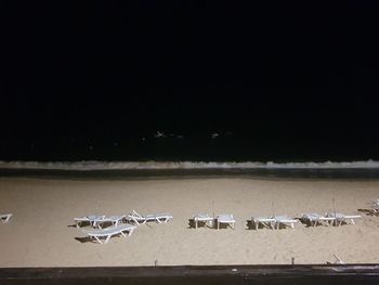 Close-up of metal structure on beach against sky at night