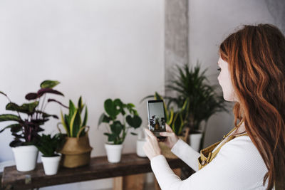 Side view of woman holding potted plant