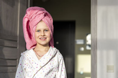 Portrait of young woman standing at home