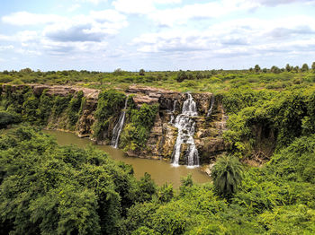 Scenic view of waterfall against sky