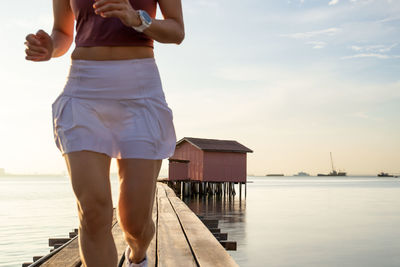 Selected focus on wooden hut wit blurred sport woman running on a bridge in foreground 