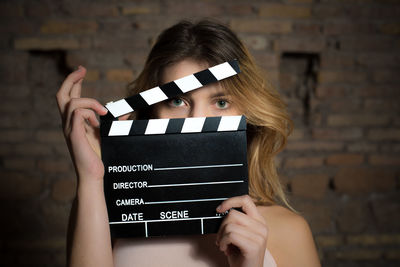 Midsection of girl holding a clapboard