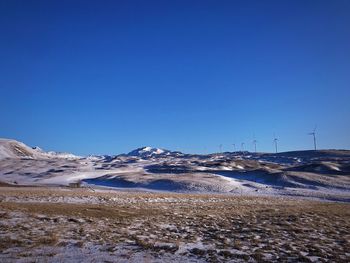 Scenic view of snowcapped mountains against clear blue sky