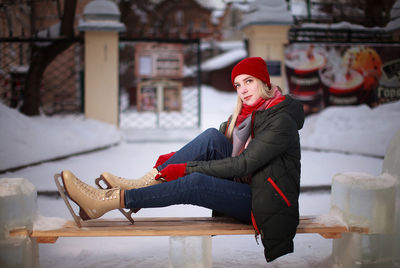 Ice skating woman siting on bench outdoor rink