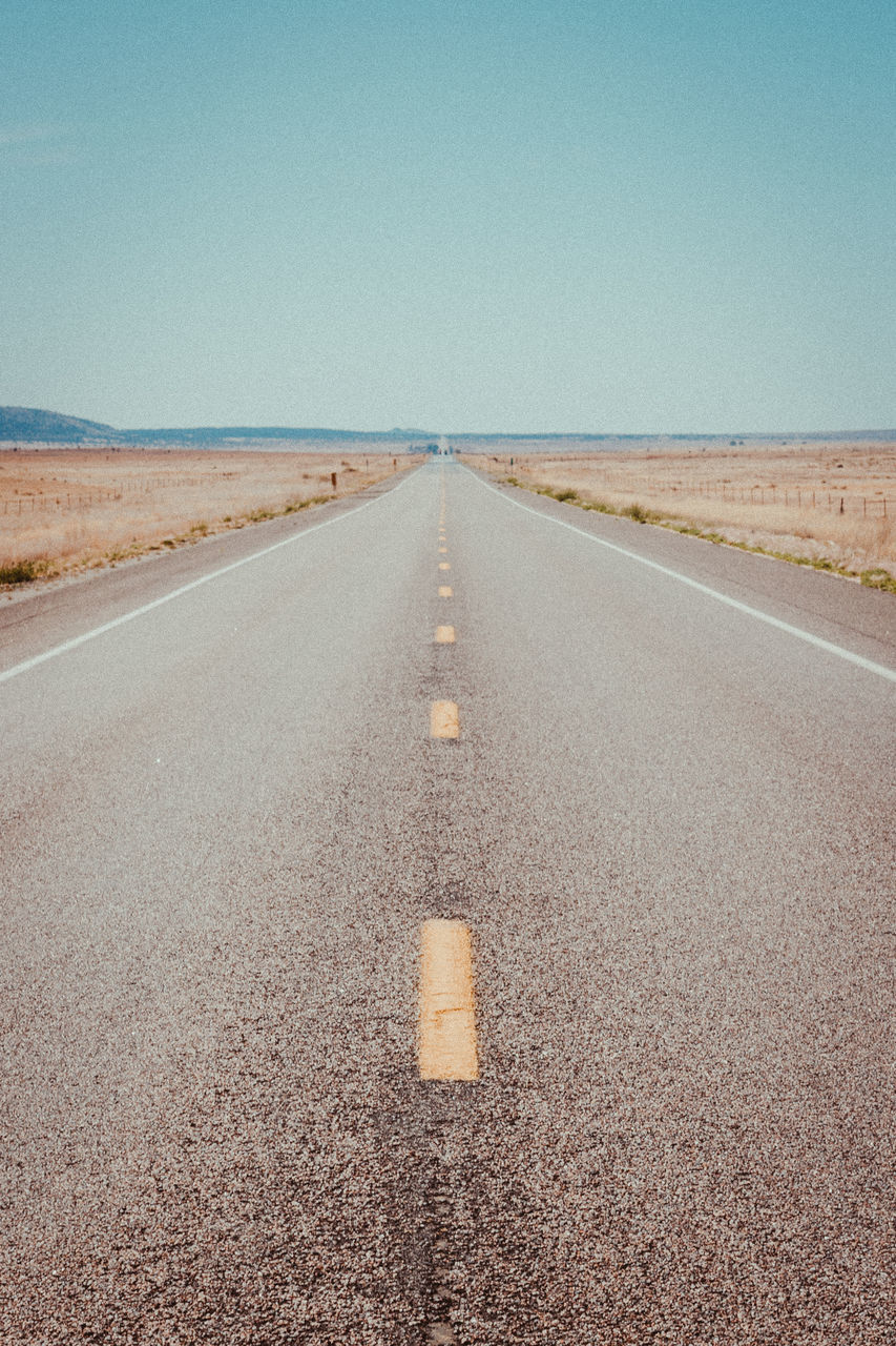 road, sky, direction, the way forward, diminishing perspective, clear sky, sign, nature, transportation, copy space, marking, road marking, day, tranquil scene, horizon, scenics - nature, no people, land, vanishing point, tranquility, outdoors, dividing line, climate