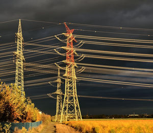 Low angle view of electricity pylon on field against sky