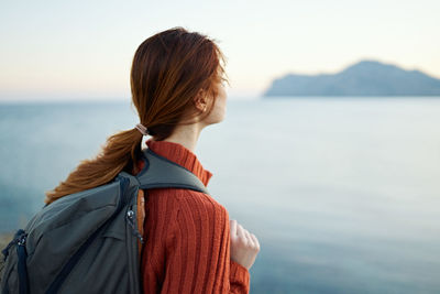 Rear view of woman looking at sea against sky