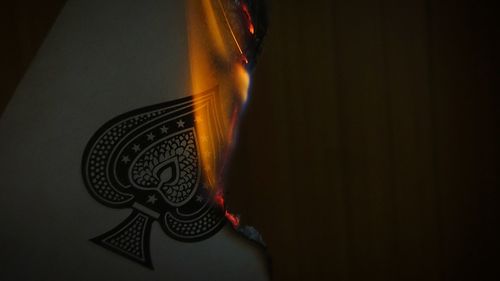 Close-up of illuminated light bulb against black background