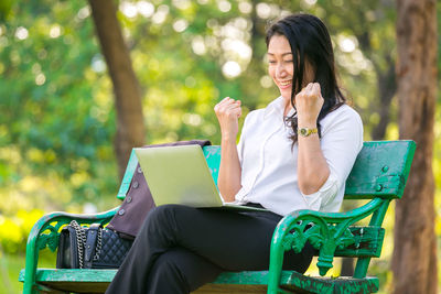 Woman sitting on bench in park