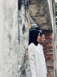 Side view of man and woman looking at wall