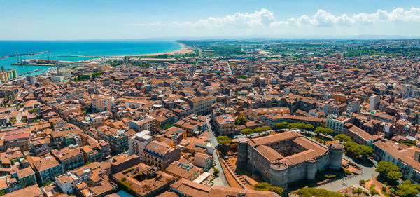 High angle view of townscape by sea against sky