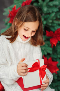 Portrait of young woman holding gift box