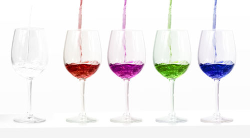 Close-up of wine glasses against white background