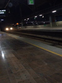 Illuminated railroad station platform at night