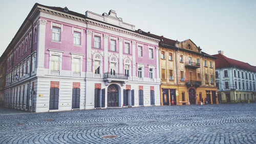 Residential building by street against sky