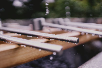 Japanese metallic ladles on wood over fountain