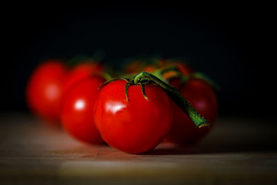 Close-up of tomatoes on table against black background