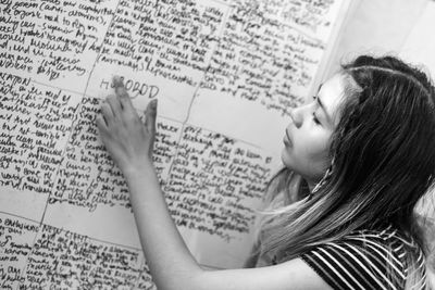 Portrait of woman reading from white board