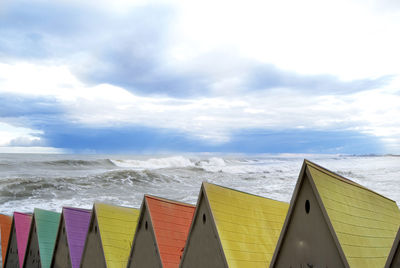 Multi colored umbrellas on beach against sky