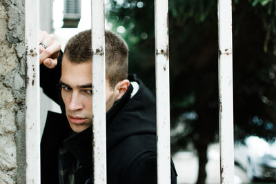 Close-up of thoughtful man looking through gate